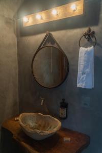 a bathroom with a bowl sink and a mirror at Pousada Monttana in Lavras Novas