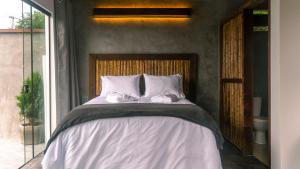 a bed with white sheets and pillows in a bedroom at Pousada Monttana in Lavras Novas