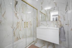 a white bathroom with a sink and a shower at Heart of Budapest Luxury Apartment with Amazing View in Budapest
