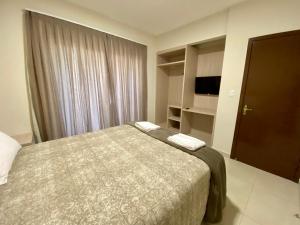 a bedroom with a bed and a large window at Residencial Shalfa in Foz do Iguaçu