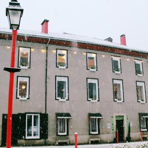 un edificio con un poste de luz roja en la nieve en Eau Berges en Vicdessos