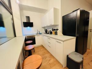 een keuken met witte kasten en een zwarte koelkast bij Big Apartment l 18 Beds l Free Parking l WiFi l in Erwitte