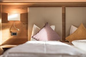 una camera da letto con un letto con cuscini sopra di Albergo Belvedere a Vigo di Fassa