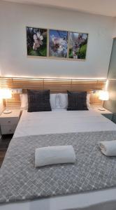 a bedroom with a large white bed with three paintings on the wall at Apartamento Happy Place Madrid in Madrid