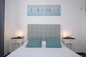 a bedroom with a white bed with sailboats on the wall at Fischer Home Roque del Este in Punta Mujeres