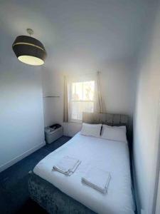 a bedroom with a white bed with two towels on it at Spacious One Bedroom Private Flat in Brixton +Wifi in London