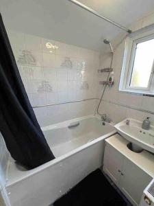 a bathroom with a bath tub and a sink at Spacious One Bedroom Private Flat in Brixton +Wifi in London