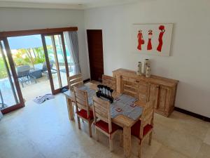- une salle à manger avec une table et des chaises en bois dans l'établissement Villa Tounga Sanur, à anur