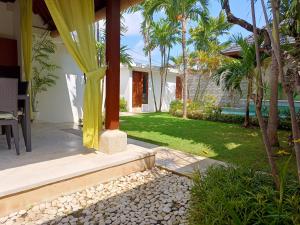 une maison avec une terrasse et une cour avec des palmiers dans l'établissement Villa Tounga Sanur, à anur