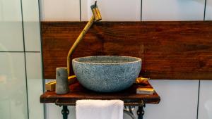 a bowl on a wooden shelf with a hose at Pousada Monttana in Lavras Novas