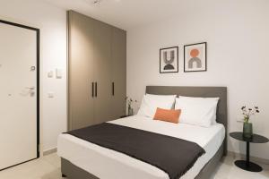 1 dormitorio con 1 cama blanca grande con manta negra en Voda Luxury Residence #801 en Athens