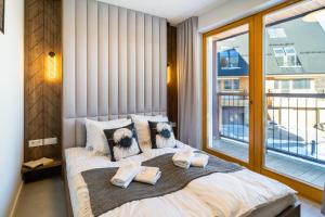 une chambre avec un lit avec deux serviettes dessus dans l'établissement Apartament Owca na wypasie by Apart Concept Podhale, à Kościelisko