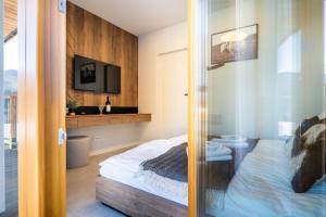 a bedroom with a bed and a tv on a wall at Apartament Owca na wypasie by Apart Concept Podhale in Kościelisko