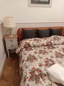 ナポリにあるAt Home Lettieriの花柄の掛け布団とランプ付きのベッド