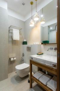 La salle de bains est pourvue de toilettes, d'un lavabo et d'un miroir. dans l'établissement Khedi Hotel by Ginza Project, à Tbilissi
