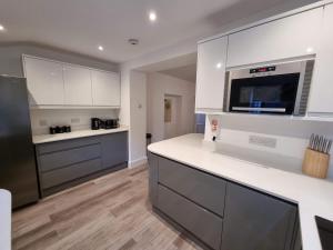 eine Küche mit weißen Schränken und einer Arbeitsplatte in der Unterkunft Well Cottage by Cliftonvalley Apartments in Bristol