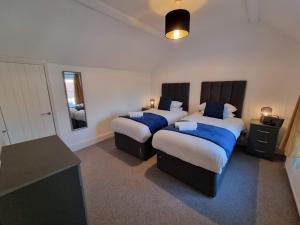 ein Hotelzimmer mit zwei Betten und einem Schreibtisch in der Unterkunft Well Cottage by Cliftonvalley Apartments in Bristol