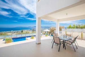d'une terrasse avec une table et des chaises et une vue sur l'océan. dans l'établissement Villa Trianta, à Neo Chorio