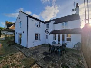 ein weißes Haus mit einem Tisch und Stühlen im Hof in der Unterkunft Well Cottage by Cliftonvalley Apartments in Bristol