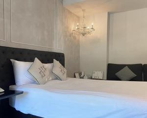 um quarto com uma grande cama branca e um lustre em Siambeach Resort em Cha Am