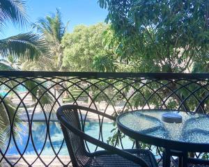 una mesa y sillas en un balcón con vistas al agua en Siambeach Resort, en Cha Am
