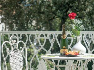 una mesa con una botella de champán y una rosa en Residenza Viani Guest House, en La Spezia