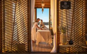 a woman is sitting at a table in a room at Lanterna Premium Camping Resort by Valamar in Poreč