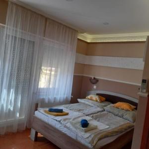 a bedroom with two beds with towels and a window at Andrea Apartman in Hajdúszoboszló