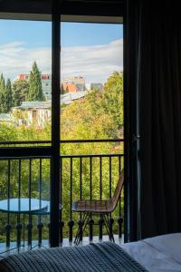 Schlafzimmer mit einem Bett und einem Fenster mit einem Tisch in der Unterkunft Khedi Hotel by Ginza Project in Tbilisi City