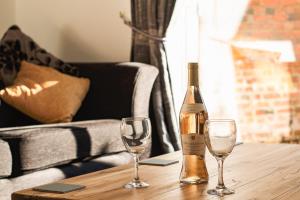 Una botella de vino y dos copas en una mesa de madera. en Meadow View, en Stamford