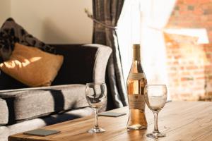 a bottle of wine and two glasses on a wooden table at Meadow View in Stamford