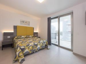 een slaapkamer met een bed en een groot raam bij Nashira Apartments in Lignano Sabbiadoro