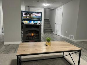 a living room with a coffee table and a fireplace at Cozy Modern and Lavish 2 Bedroom Basement Suite in Winnipeg