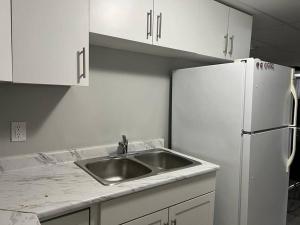 Una cocina con fregadero y refrigerador blanco. en Cozy Modern and Lavish 2 Bedroom Basement Suite, en Winnipeg 5 fotos más