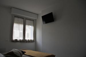 a bedroom with a bed and a television on the wall at New apartment close to the Cinque Terre in La Spezia