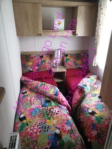 a room with two beds and a table in it at Flamingo Land - Cedar Wood CW30 in Kirby Misperton