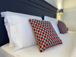 2 cuscini posti sopra un letto di Hotel Estée a Desenzano del Garda