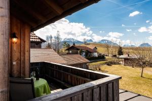 a balcony with a table and a view of mountains at Best Butler Alp Villa 11 Personen I Blockhütte I Parken I Lagerfeuer I Netflix in Hopferau