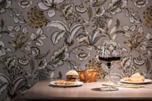 una mesa con un sándwich y una copa de vino en HOTEL & SPA Goldene Rose, en Dinkelsbühl