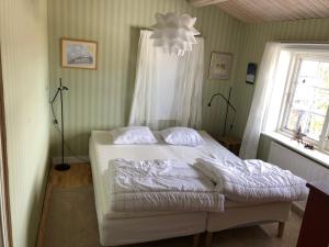 a bedroom with a bed with white sheets and a window at Stuga , Funäsdalen in Funäsdalen