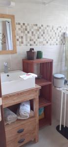 a bathroom with a sink and a wooden cabinet at Loc' Avirons 10 bis in Les Avirons