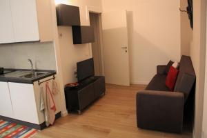 a kitchen and a living room with a couch at The Blue Nest - Red Apartment near 5 Terre in La Spezia