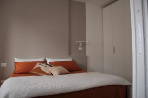 Schlafzimmer mit einem Bett mit orangefarbenen und weißen Kissen in der Unterkunft The Blue Nest - Red Apartment near 5 Terre in La Spezia