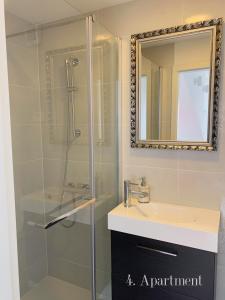 een badkamer met een douche, een wastafel en een spiegel bij ApartHouse Porto in Piran