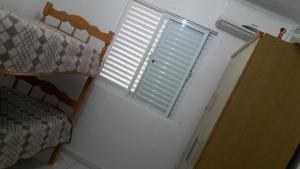 sypialnia z łóżkiem i oknem z okiennicami w obiekcie Casa Praia em Ingleses- Florianópolis w mieście Florianópolis