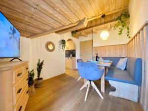 a living room with a blue couch and a table at Best Butler Alp Villa 11 Personen I Blockhütte I Parken I Lagerfeuer I Netflix in Hopferau