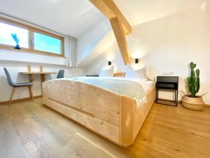 a bedroom with a large wooden bed in a room at Best Butler Alp Villa 11 Personen I Blockhütte I Parken I Lagerfeuer I Netflix in Hopferau