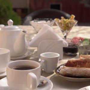 - une table avec une tasse de café et une assiette de pain grillé dans l'établissement UYUT INN Hotel, à Samarcande