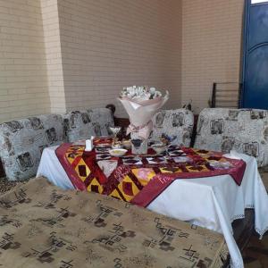 uma mesa com um vaso de flores em UYUT INN Hotel em Samarcanda