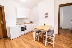 a small kitchen with a wooden table and chairs at FULL HOUSE 3 Bedroom Apartment Halle NH14 in Halle an der Saale